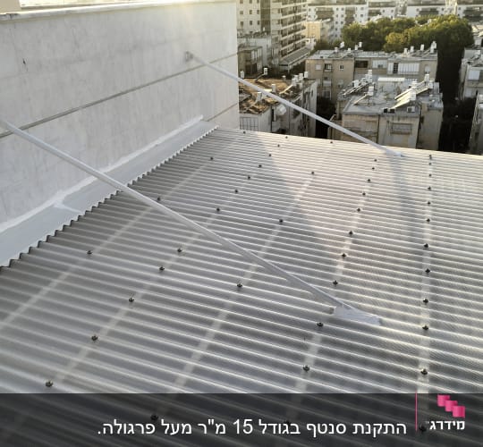 גג מתכת עם ברגים ותמיכה על קיר בטון
